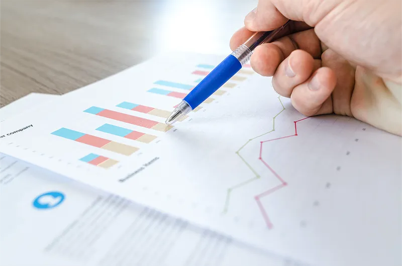 Hand wijst naar grafieken en datavisualisaties op een rapport